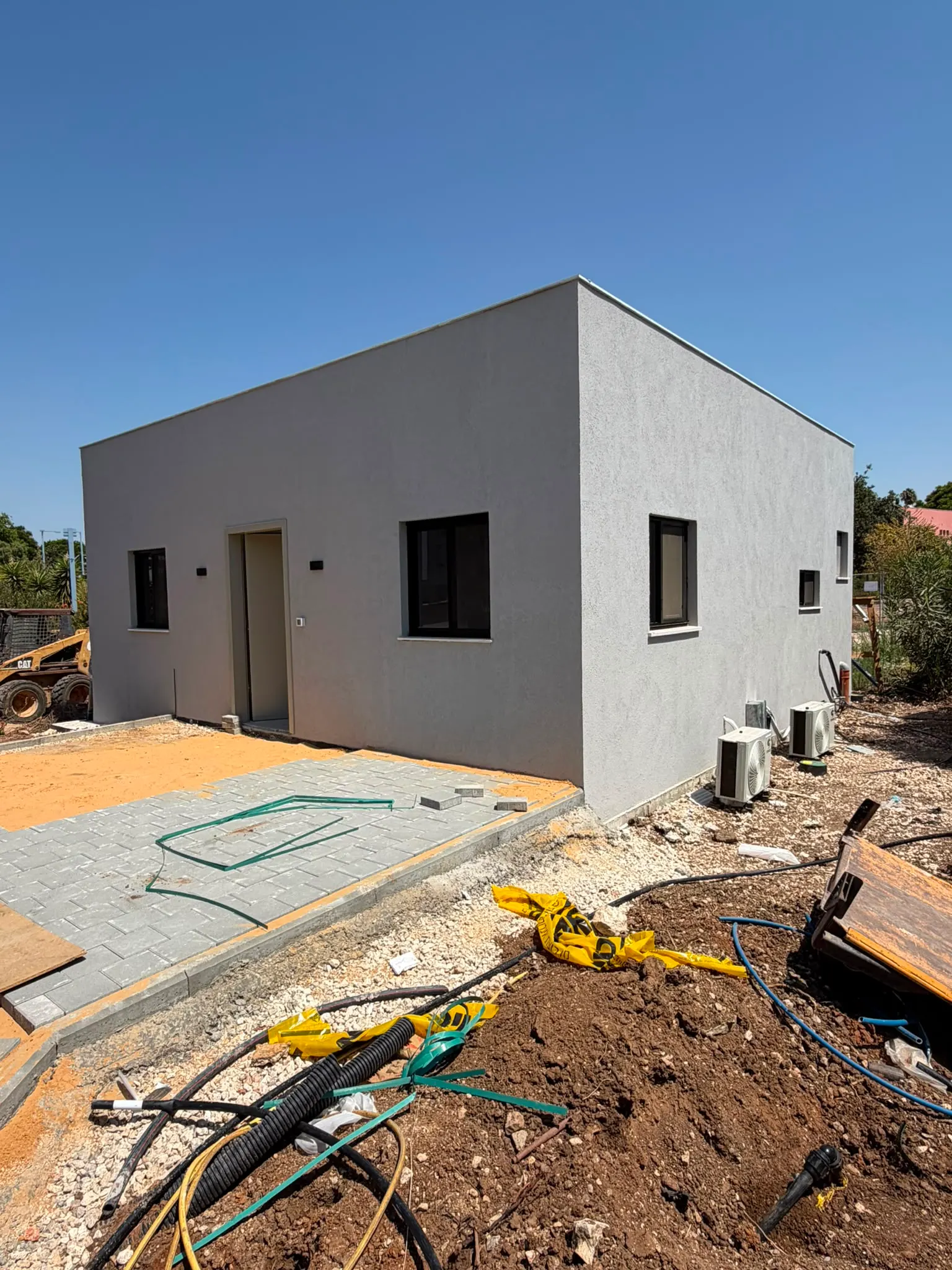בית יביל מודרני בצורת קובייה עם חלונות גדולים